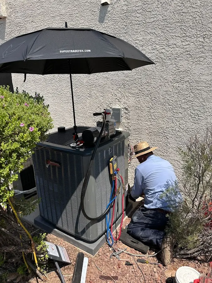 HVAC technician performing outdoor AC maintenance in Hutchins