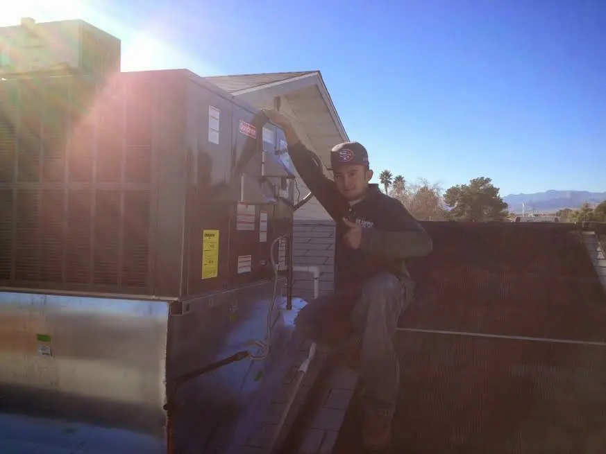 HVAC technician performing HVAC Inspection on a rooftop unit in Hutchins